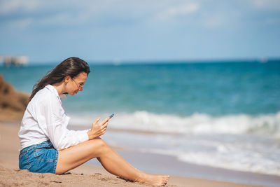 Young woman sitting on beach