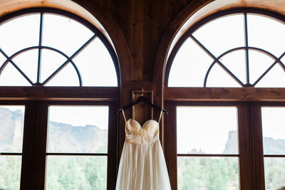 Rear view of woman standing against window