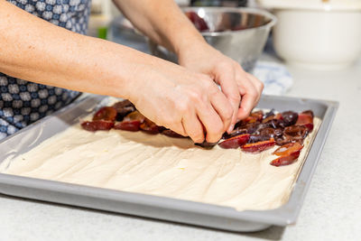 Close-up of person preparing food on cutting board at home