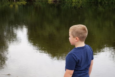 Rear view of boy against lake