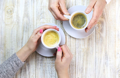 Midsection of woman holding coffee on table