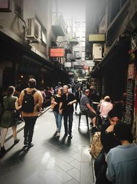 People walking on street amidst buildings in city