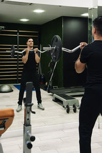 Young man doing biceps with the z-bar at the gym