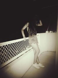 Rear view of woman standing by railing
