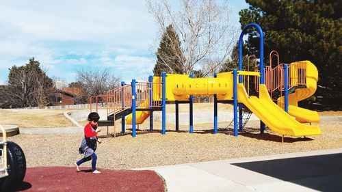 Girl walking against jungle gym at playground