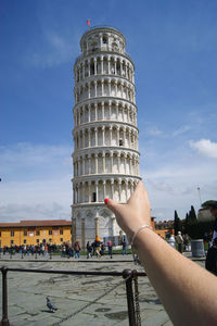 Optical illusion of woman holding leaning tower of pisa