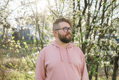 Portrait of young man wearing sunglasses against trees