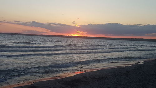 Scenic view of sea against romantic sky at sunset