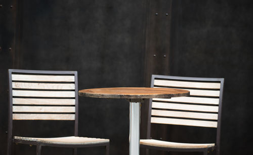 Empty chairs and table at sidewalk cafe