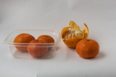 Close-up of orange fruit on white table