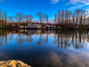 Reflection of trees in lake against blue sky