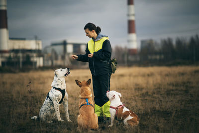 Woman with dogs standing on grass