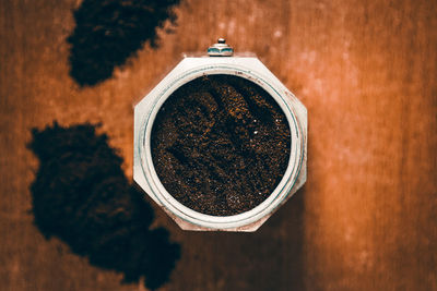 Directly above shot of ground coffee in jar on table