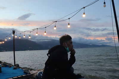 Portrait of a young man sitting by the beach