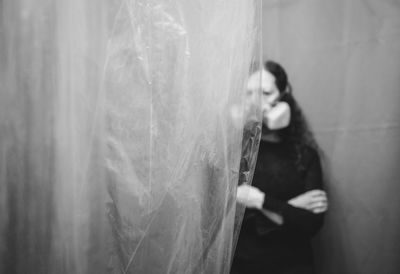 Woman looking at camera while standing in glass