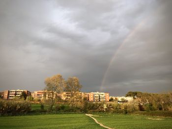 Scenic view of rainbow over building against sky