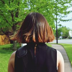 Rear view of woman standing on footpath at park