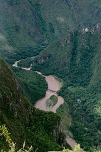 Aerial view of river flowing amidst mountains covered with trees 