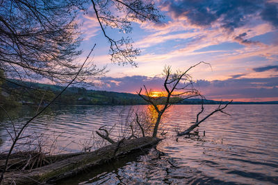 Scenic view of lake against sky at sunset