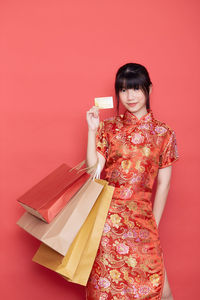 Woman standing against red background