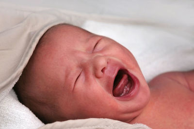 Close-up of baby boy sleeping on bed