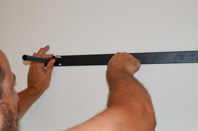 Close-up of man working on wall against white background