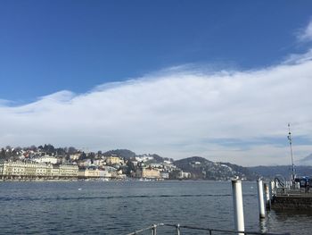 Scenic view of sea by buildings against sky