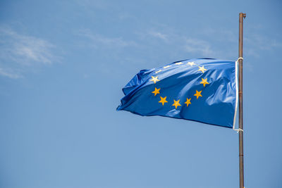 Low angle view of european union flag against blue sky