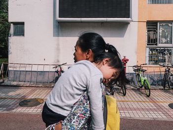 Mother and girl with arms raised