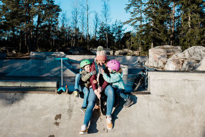 Mom and her kids laughing and having fun at a skatepark