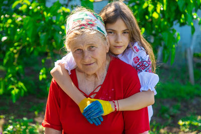 Portrait of smiling grandmother carrying granddaughter