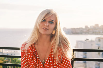 Portrait of a young attractive blue-eyed blonde woman with long hair looking at camera and smiling