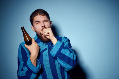 Portrait of young man against blue background