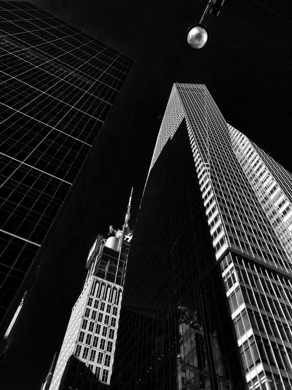 LOW ANGLE VIEW OF MODERN SKYSCRAPER AGAINST SKY AT NIGHT