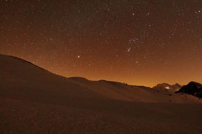Scenic view of mountains against sky at night
