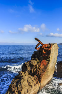 Scenic view of rocks on beach against sky