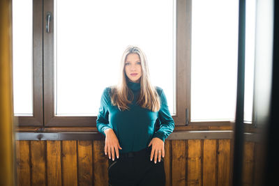 Full length of woman standing against window