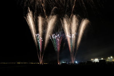 Low angle view of firework display at night