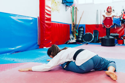 Rear view of woman lying on bed