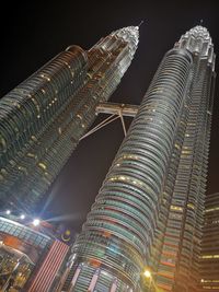 Low angle view of illuminated buildings against sky at night