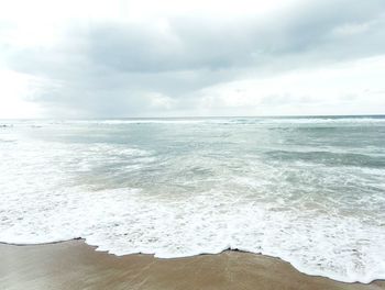 Scenic view of sea against cloudy sky