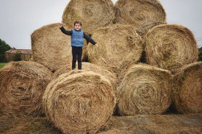 Full length of man with hay bales on field