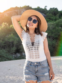 Midsection of young woman wearing sunglasses standing outdoors