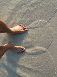 Low section of person relaxing on beach