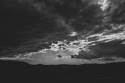 Low angle view of dramatic sky over silhouette landscape
