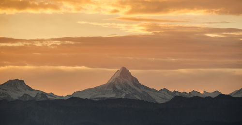 Scenic view of snowcapped mountains against sky during sunset