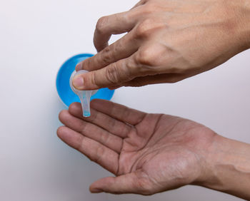 Close-up of man holding hands over white background