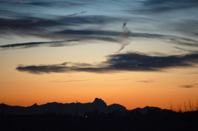 Silhouette mountain against dramatic sky