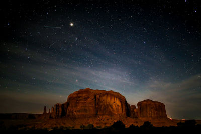 Scenic view of rock formation against sky at night