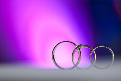 Close-up of rings on table against illuminated background